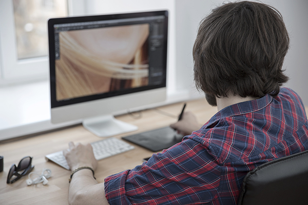 Woman looking at computer editing photo